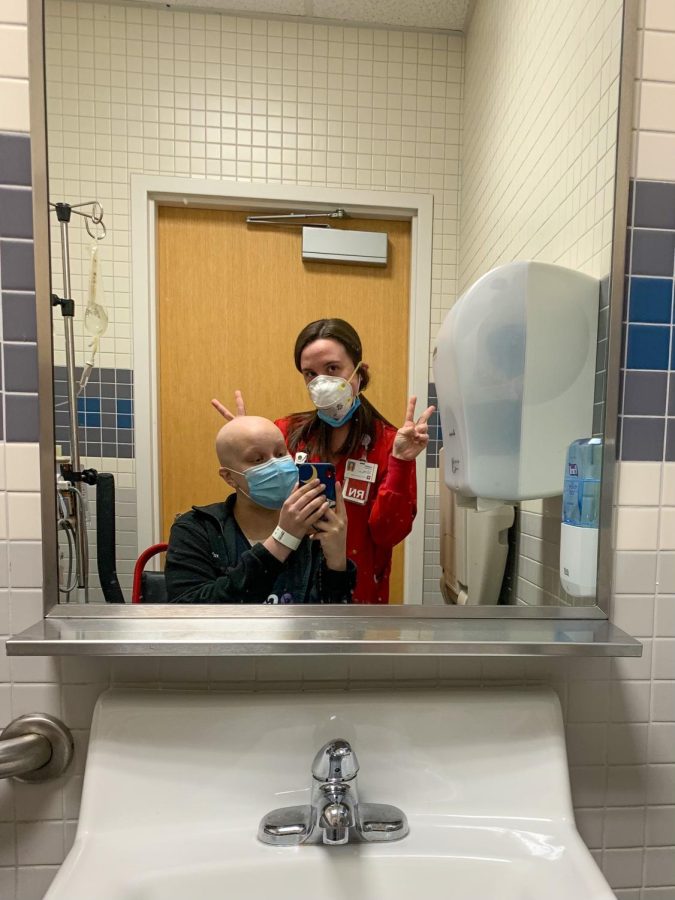 Allison Hale taking a selfie with a nurse in the mirror.