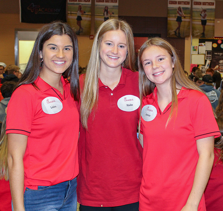 Our pleasure! Juniors Laira Cloin, Halle Pohl and Jenna Loyd show their love of chicken sandwiches and waffle fries as Chick-fil-A employees.