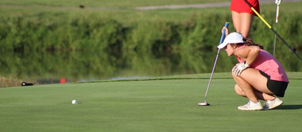 Senior Kaitlyn Walker reads the green as she aligns her putt at Cambridge Golf Course when the Lady Titans hosted Mater Dei on Senior Night.