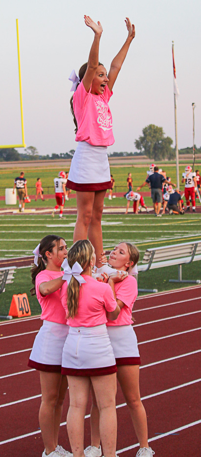 Freshman Isla Luhring waves to the crowd during a lift at the home football game against Heritage Hills on Sept. 22. 