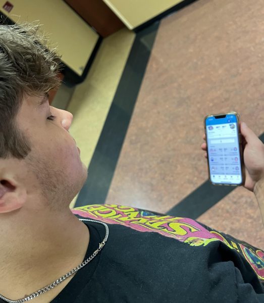 Senior Mason Scheller takes a quick look at his fantasy football standings while on his way to football practice. Fantasy football players have quick access to their fantasy teams on their phones.