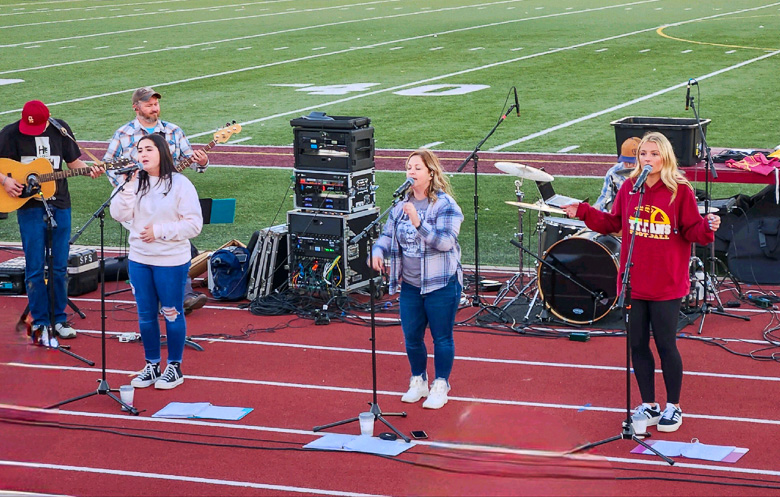 Sophomore Josalyn Turner and senior Cassie Reeves raise their voices in song at Gibson Southerns first Fields of Faith gathering.