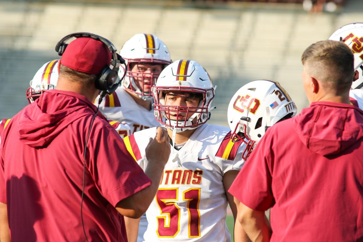 Head+football+coach+Nick+Hart+explains+the+next+play+to+senior+Teagan+Baker+when+the+team+faced+off+against+Boyle+County+High+School+to+start+the+2023-2024+season.+The+Titans+traveled+to+Western+Kentucky+University+to+meet+the+Rebels.
