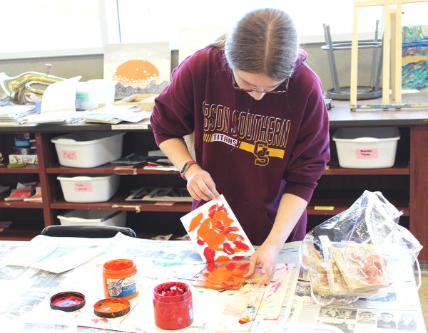 Sophomore Sierra Mills pulls her paper back to reveal the print she created.