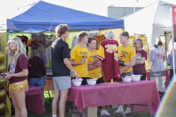 Members of the Titan baseball team, seniors Connor Marvel, Karson Britton, Brody Knowles and sophomore Crewe Hasenour, welcome alumni during the 50th anniversary celebration.