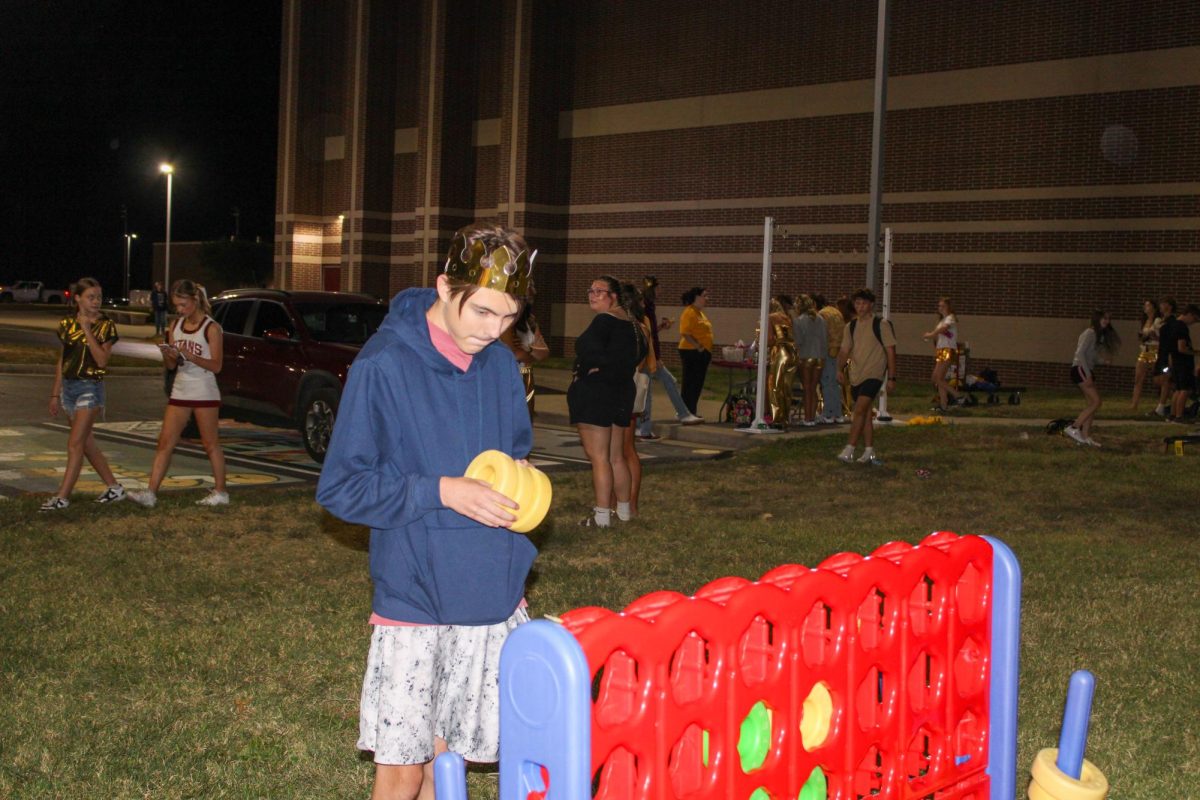 Freshman Patrick Hughes carefully considers where to place his next disc in a game of Connect Four at the Homecoming Legacy Lawn Party.