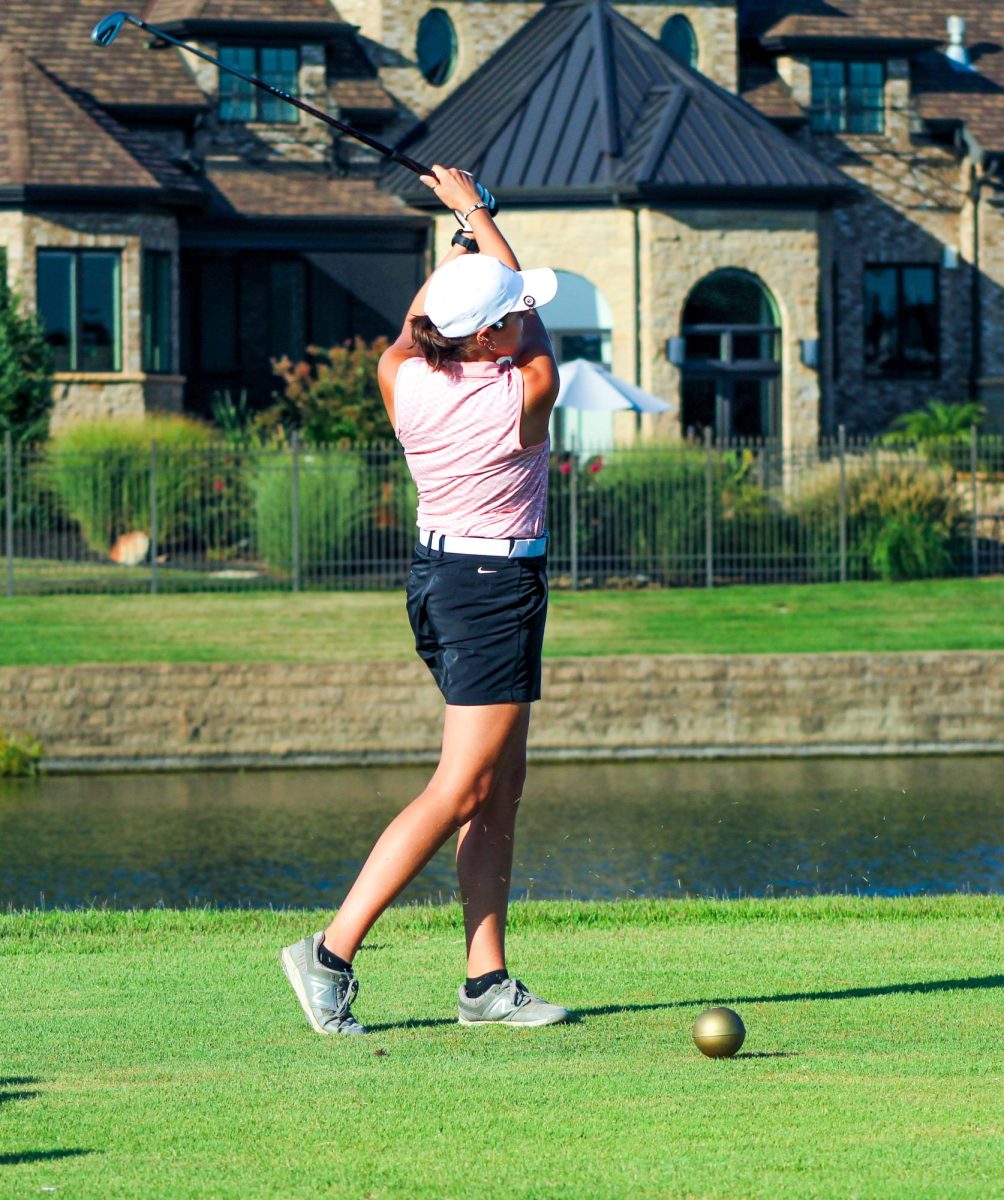 Senior Olivia Alston watches her ball after she drives from the tee box.