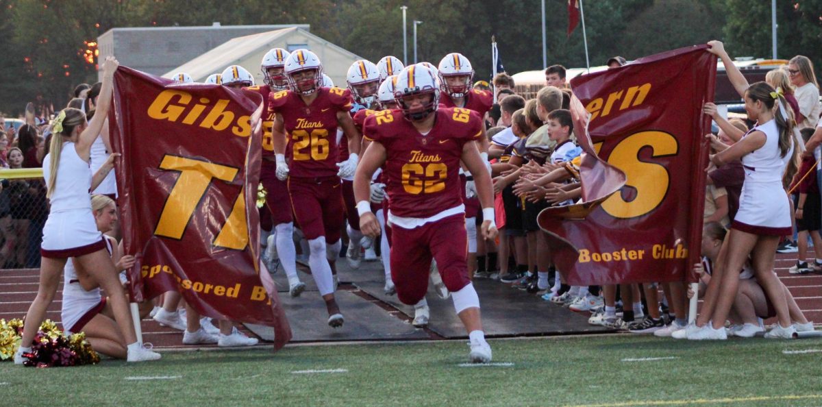 Senior team captain Bobby Robinson leads the Titans to the field to take on the Henderson County Colonels.